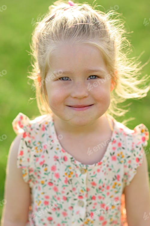 Preview: Little girl 3 years old in a summer sundress in the park. Summer time.