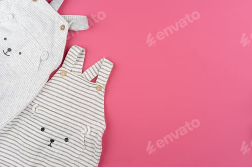 Preview: baby clothes on pink background top view