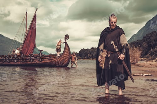 Preview: Viking warrior with sword standing near Drakkar on the seashore