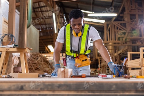 Preview: Focused carpenter sketching woodwork design on paper