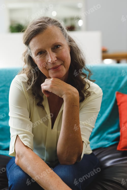 Preview: Portrait of happy senior caucasian woman in living room sitting on sofa, looking to camera
