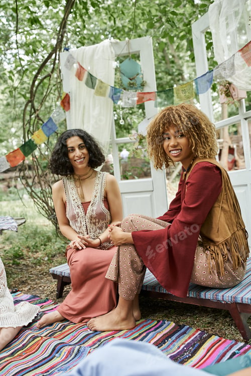 Preview: positive and stylish multiethnic women spending time together outdoors in retreat center