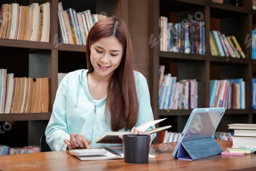 Preview: Female student is using calculator to doing homework assignment of finance and accounting