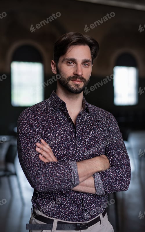 Preview: Portrait of young businessman standing indoors in office, looking at camera