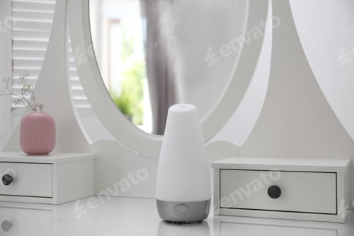 Preview: Essential oils diffuser on white table in room. Space for text