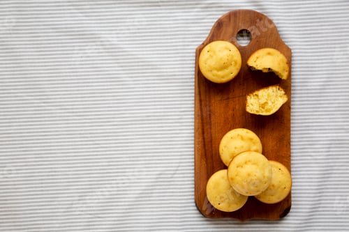 Preview: Homemade Cornbread Muffins on a rustic wooden board, overhead view.