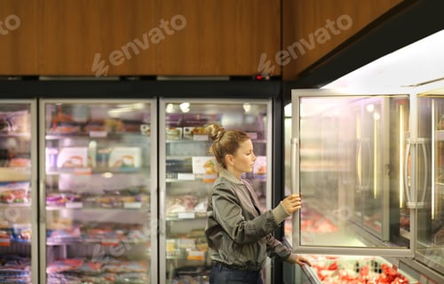 Preview: Woman Choosing Frozen Food From A Supermarket Freezer