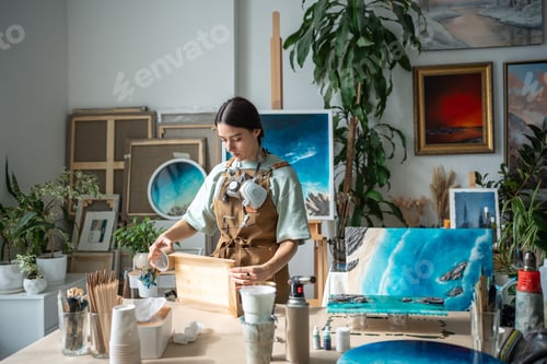 Preview: Dedicated craftswoman carefully tapes board edges before epoxy resin work, artistic precision work