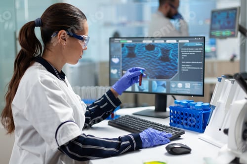 Preview: Specialist biologist researcher holding blood medical test tubes analyzing virus diagnostic
