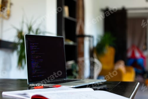 Preview: Laptop computer and notebook with pen on a table in home office