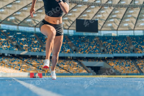 Preview: Female athlete taking position on her marks to start off the run