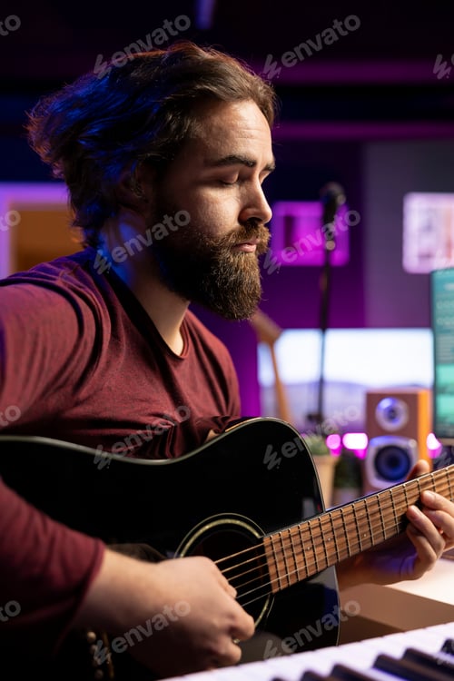 Preview: Musician creating a song by playing acoustic guitar in home studio
