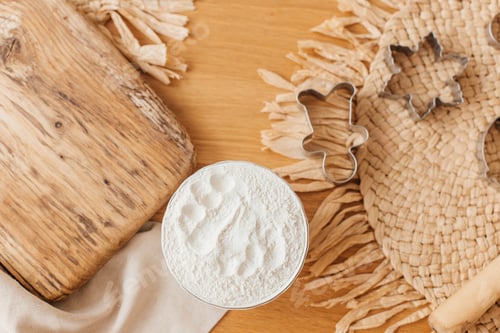 Visualização: Farinha, tábua de madeira, rolo e cortadores de biscoitos em uma mesa de madeira. Fundo de biscoitos assados
