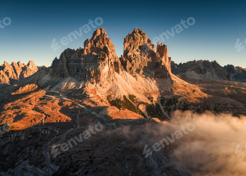 Preview: Scenic view of rugged Tre Cime di Lavaredo mountain and foggy in the morning at Dolomites, Italy