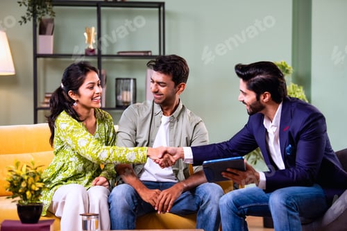 Preview: Indian family investment consultation at home with professional agent reviewing paperwork