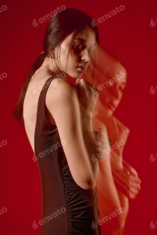 Preview: Stylish woman poses elegantly against a vibrant red backdrop showcasing modern fashion trends