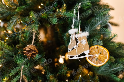 Preview: Christmas tree with a pair of skates toy hanging from it and oranges on the tree