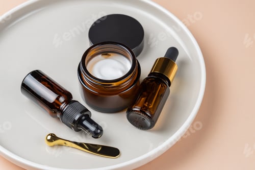 Preview: Cosmetics packaging. Set of different cosmetic bottles of cream or serum on a ceramic tray. Blank
