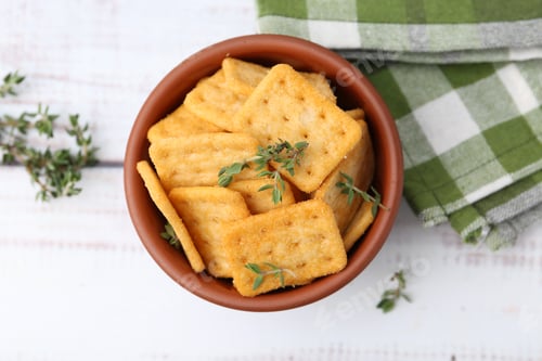 Preview: Tasty salty crackers with thyme on white wooden table, flat lay