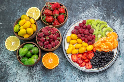 Vista previa: top view fresh fruits raspberries strawberries and feijoa on the light-grey background ripe healthy