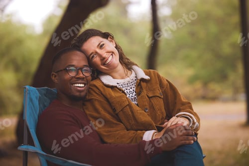 Preview: Shot of a woman sitting on her boyfriends lap while out camping in the wilderness