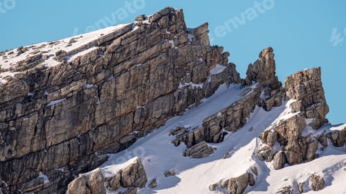 Preview: Beautiful view of a rocky cliff covered in snow.