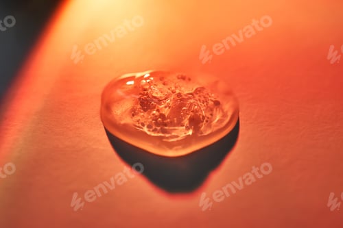 Preview: A drop of sunscreen body gel in the orange sunset light.