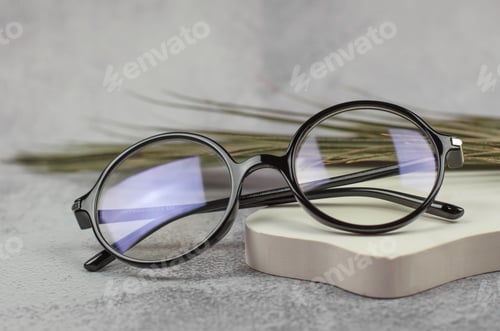 Preview: Stylish round glasses for vision on a beige podium, close-up