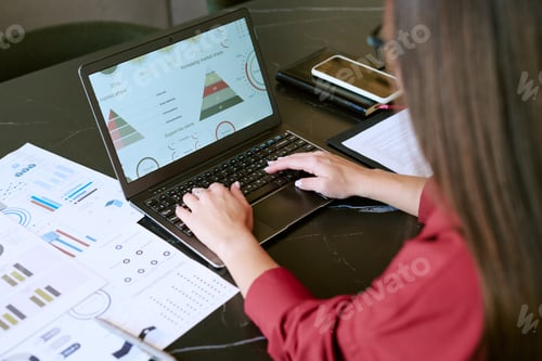 Preview: Young Adult Asian Woman Analyzing Business Data on Laptop during Morning