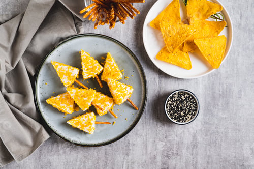 Preview: Fake Christmas trees made from triangle cheese in nacho crumbles on a plate top view