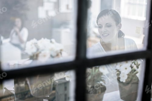 Preview: Window view of female designer at work in design studio