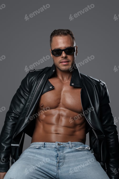 Preview: Strong and stylish man sitting on chair against grey background