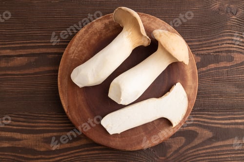 Preview: King Oyster mushrooms or Eringi (Pleurotus eryngii) on brown wooden. Top view.