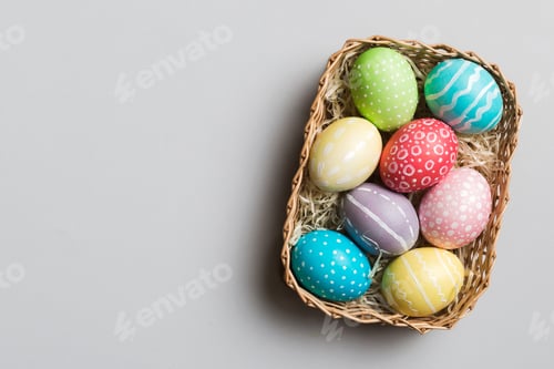 Preview: Multi colors Easter eggs in the woven basket on colored background . Pastel color Easter eggs