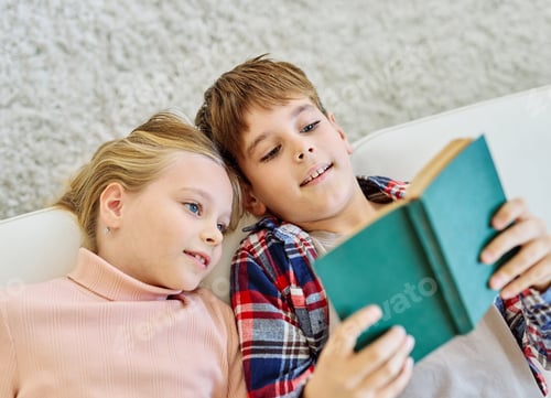 Preview: Children Reading Together Indoors on a White Couch