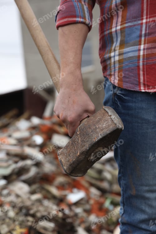 Preview: Man with sledgehammer on blurred background, closeup