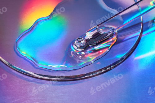 Preview: Pipette with sample of cosmetic product in petri dish on iridescent holographic background