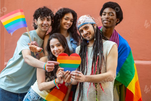 Preview: Young activists showing rainbow heart and flags celebrating gay pride