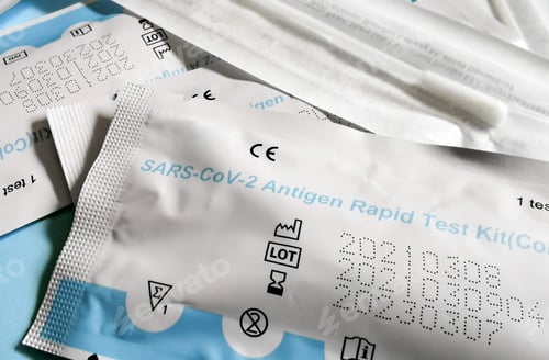 Preview: Close-up image of sealed rapid covid antigen test kits and swabs.