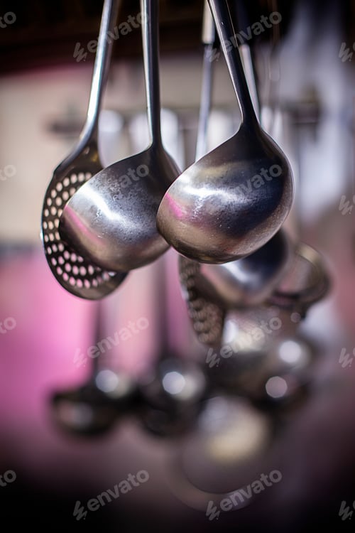 Preview: Metal kitchen utensils hung on a pink background
