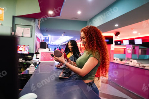 Preview: Young women choosing bowling shoes at the bowling alley