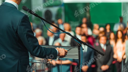 Preview: Male Speaker Standing In Front Of Microphones
