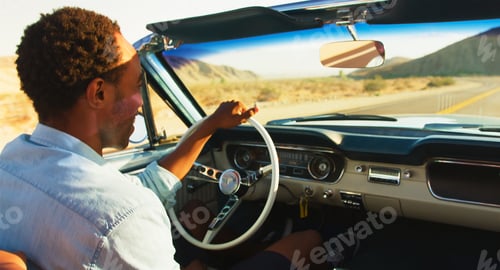 Preview: Close Up Of Man Driving Classic Open Top Car On Road Trip Through Countryside At Sunset