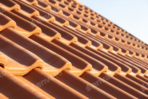 Preview: Overlapping rows of yellow ceramic roofing tiles covering residential building roof