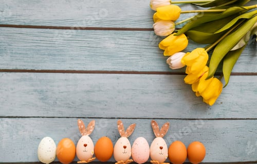 Preview: Colorful easter eggs and yellow tulips on old blue rustic wooden background, Top view with copy spac