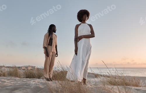 Preview: Black couple standing on sandy beach at sunset