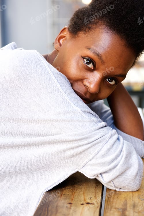 Preview: Young african woman sitting at table