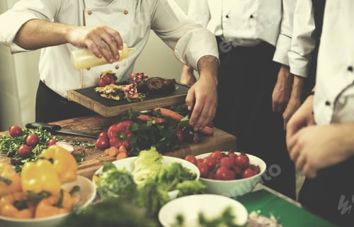 Preview: team cooks and chefs preparing meal