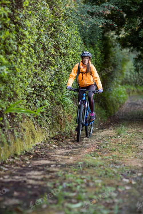 Preview: Female Biker Cycling In Countryside Forest