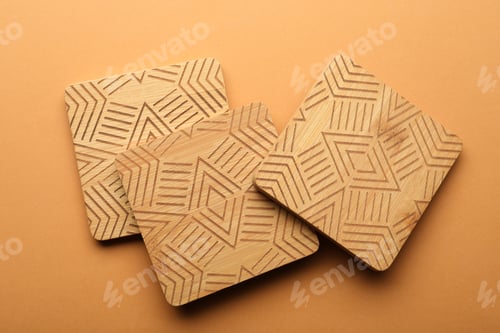Preview: Stylish wooden cup coasters on orange background, flat lay